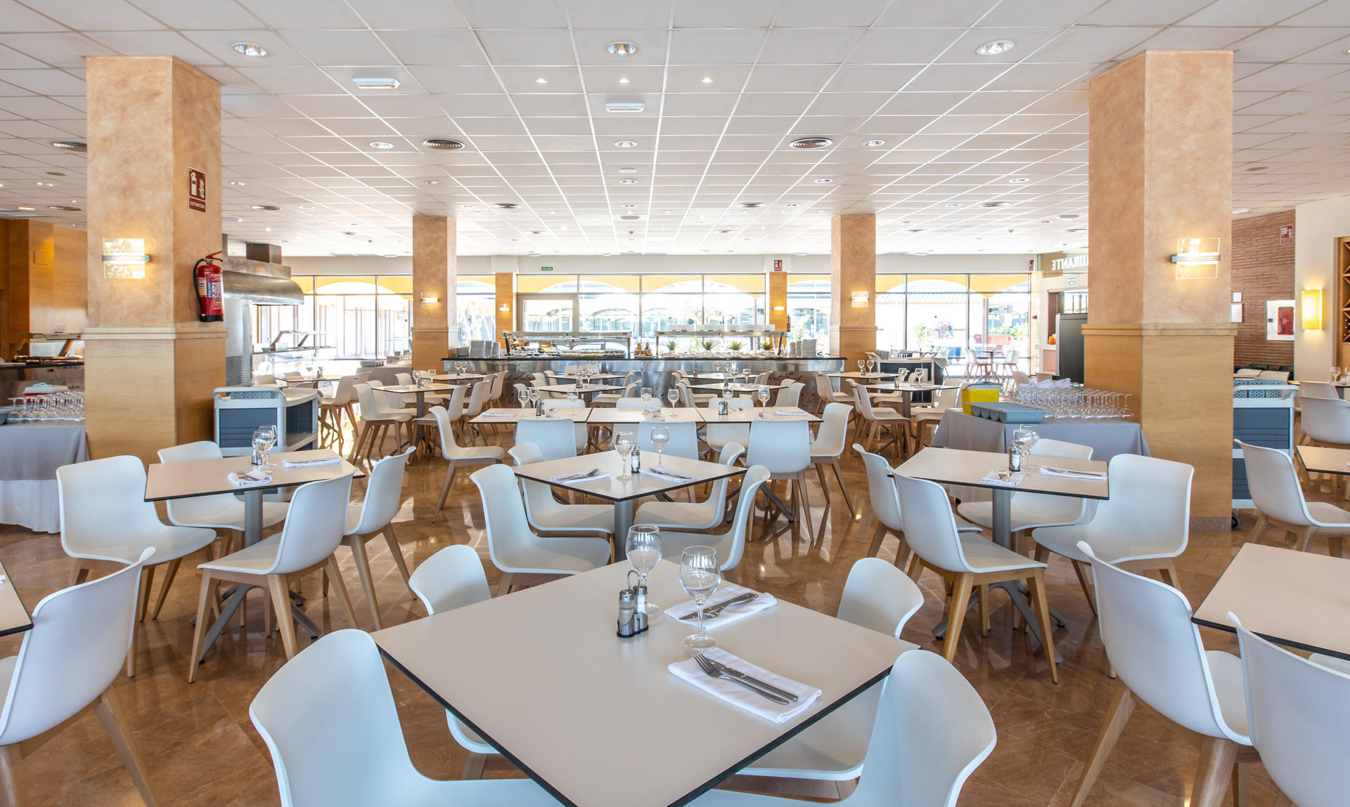 Dining room with tables set with crystal glasses, cutlery and napkins.